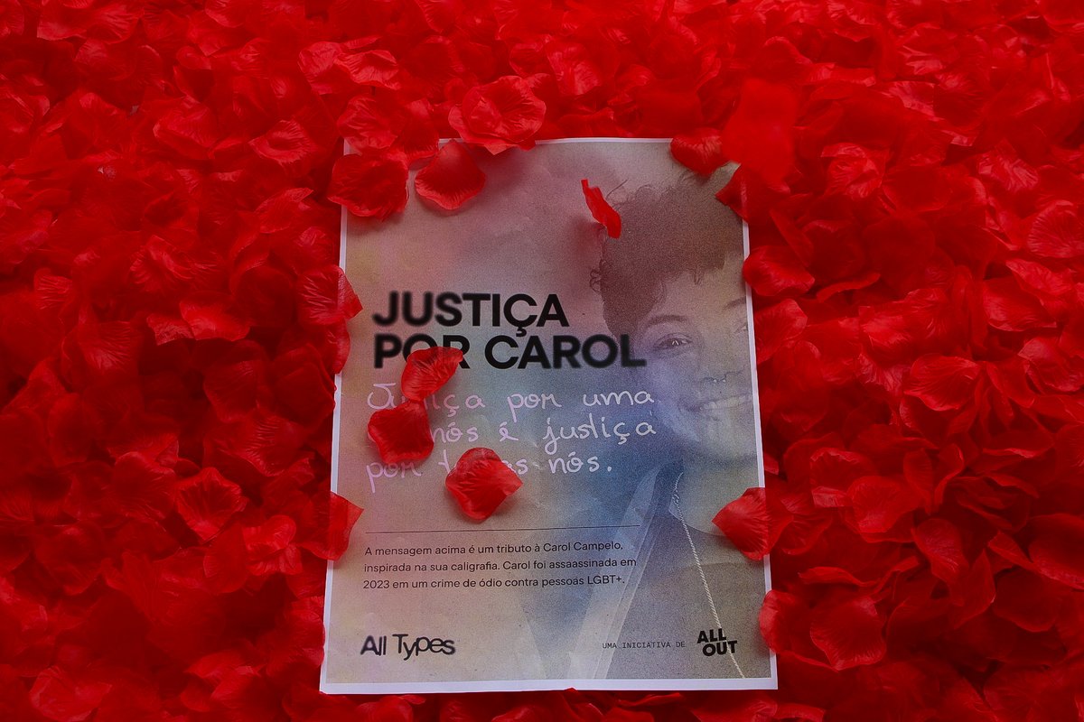 The image shows a sign with Carol's face among the sea of red rose petals.