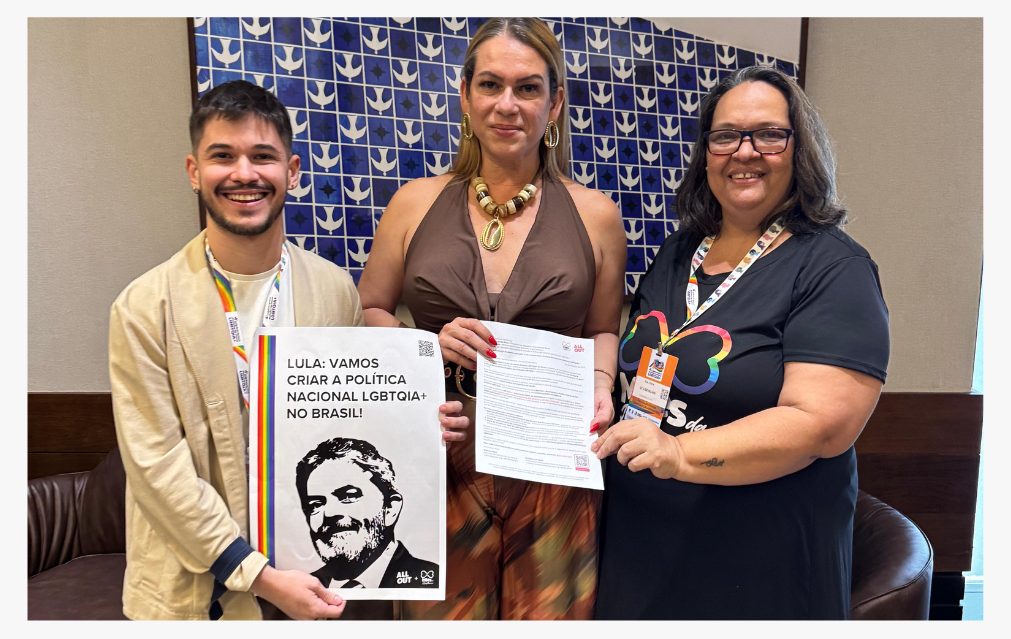 The image shows Marcos Melo, LGBT+ activist from All Out, and Gi Carvalho, from the Mães da Resistência Association, delivering the signatures of the petition to the National Secretary for LGBTQIA+ Rights, Symmy Larrat.