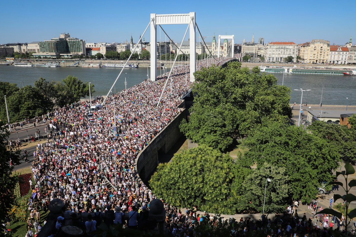 Thousands crossing a bridge during Budapest Pride. Alt-text: Tens of thousands of people march peacefully across a bridge in Budapest during Pride, despite an official ban.